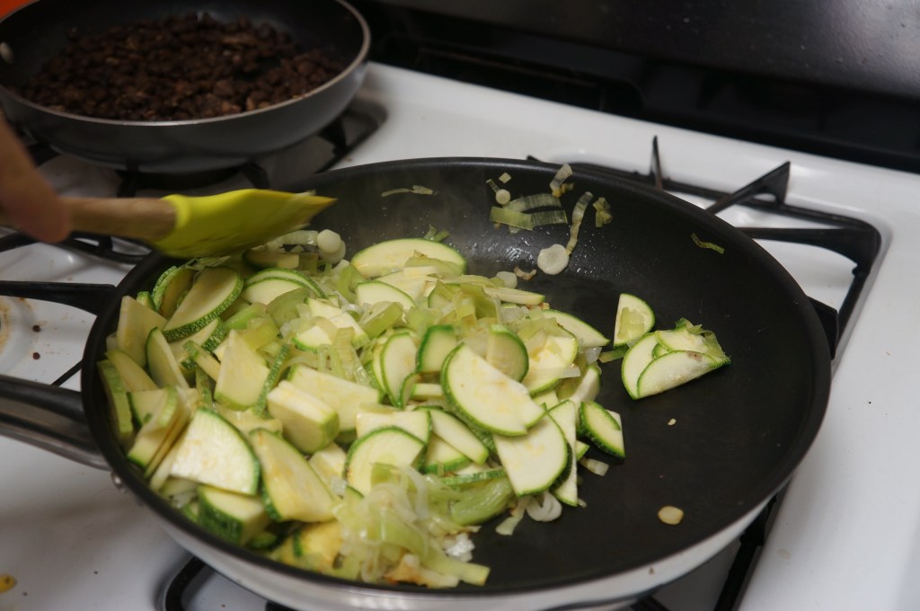 Cooking up zucchini, leeks, garlic scapes and beans for quesadillas